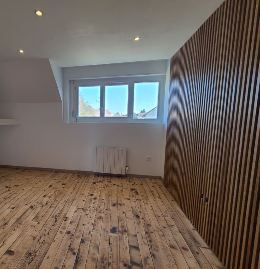 Appartement rénové par MS Promotion : parquet ancien restauré et mur en tasseaux de bois