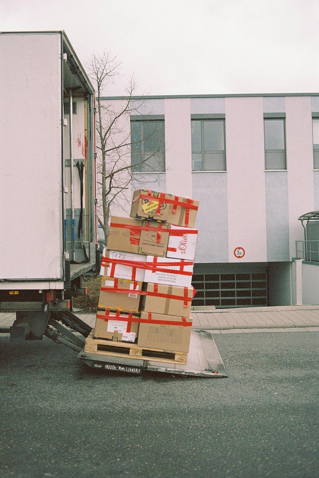 Stacked cardboard boxes being loaded onto a moving truck during an office move