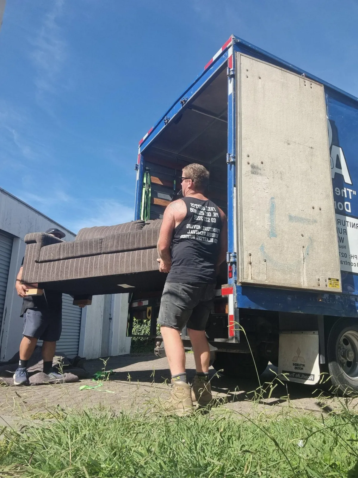 A1 Contracting team carefully loading a couch into a moving truck