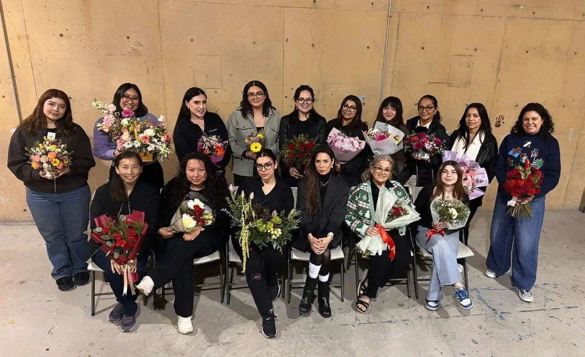 Render fotográfico del aula principal en CEART Tijuana con mesas de trabajo y arreglos florales en primer plano