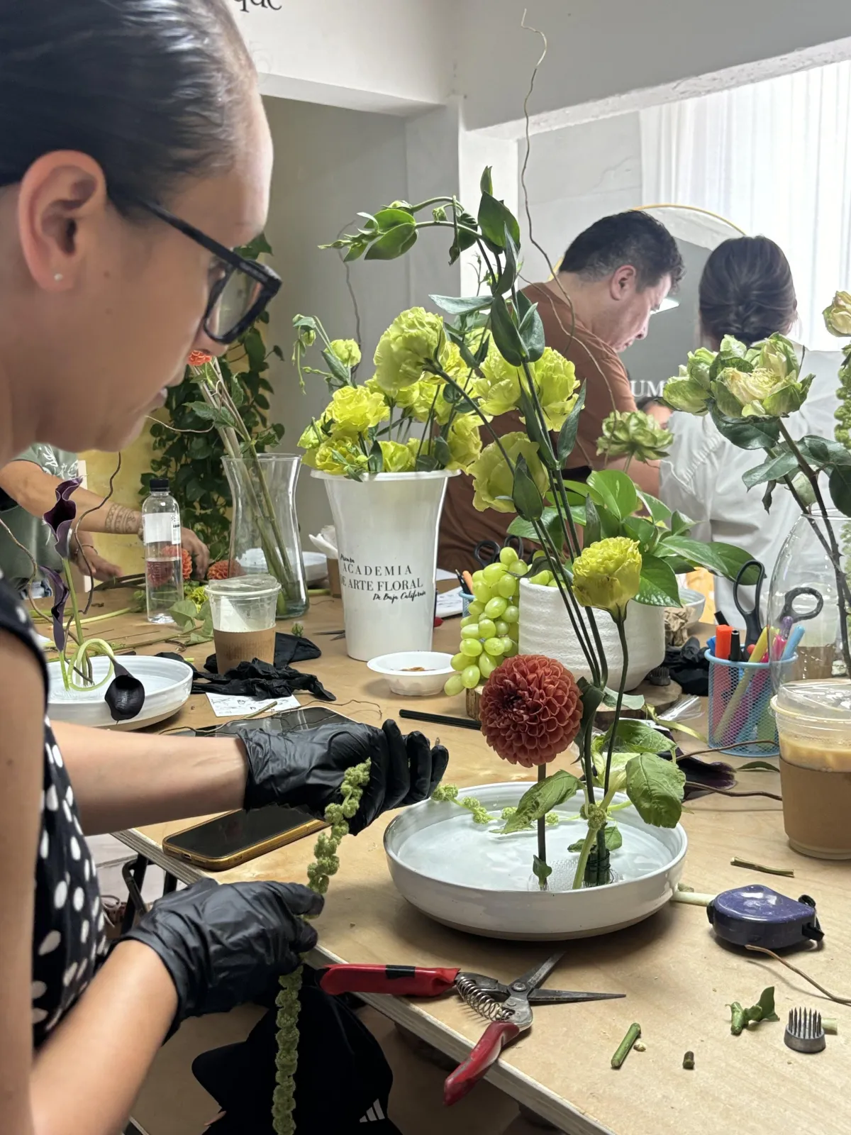 Captura de pantalla del taller práctico mostrando un close-up de la sección de montaje con técnicas de mecánica floral y herramientas