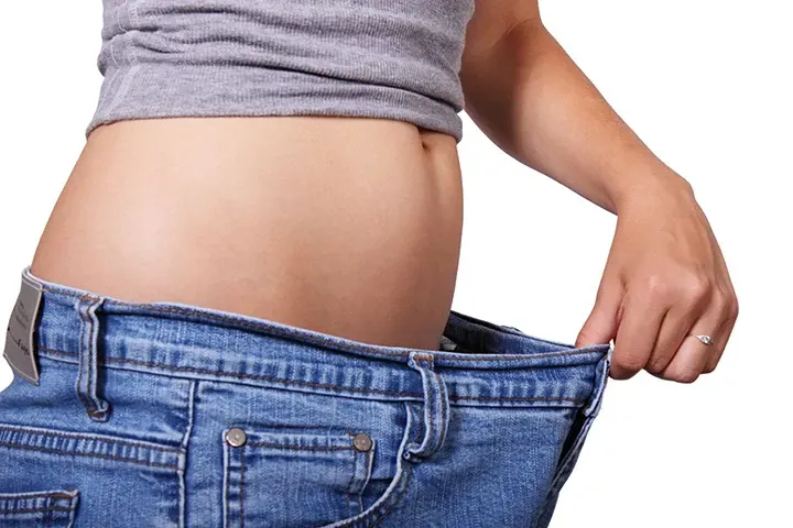 Woman Holding Out Oversized Jeans After Losing Weight Safe Non-Risky Weight Loss