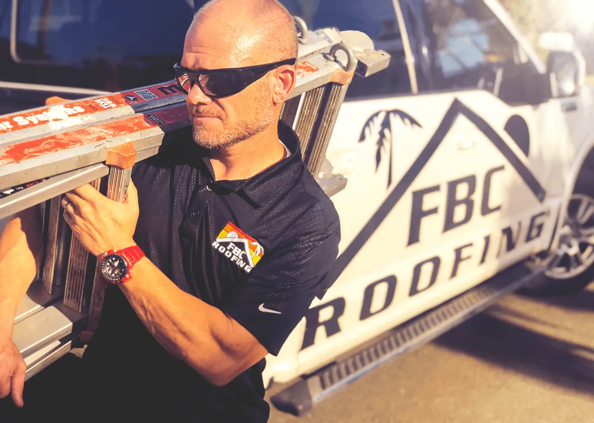 FBC roofing installer carrying a ladder