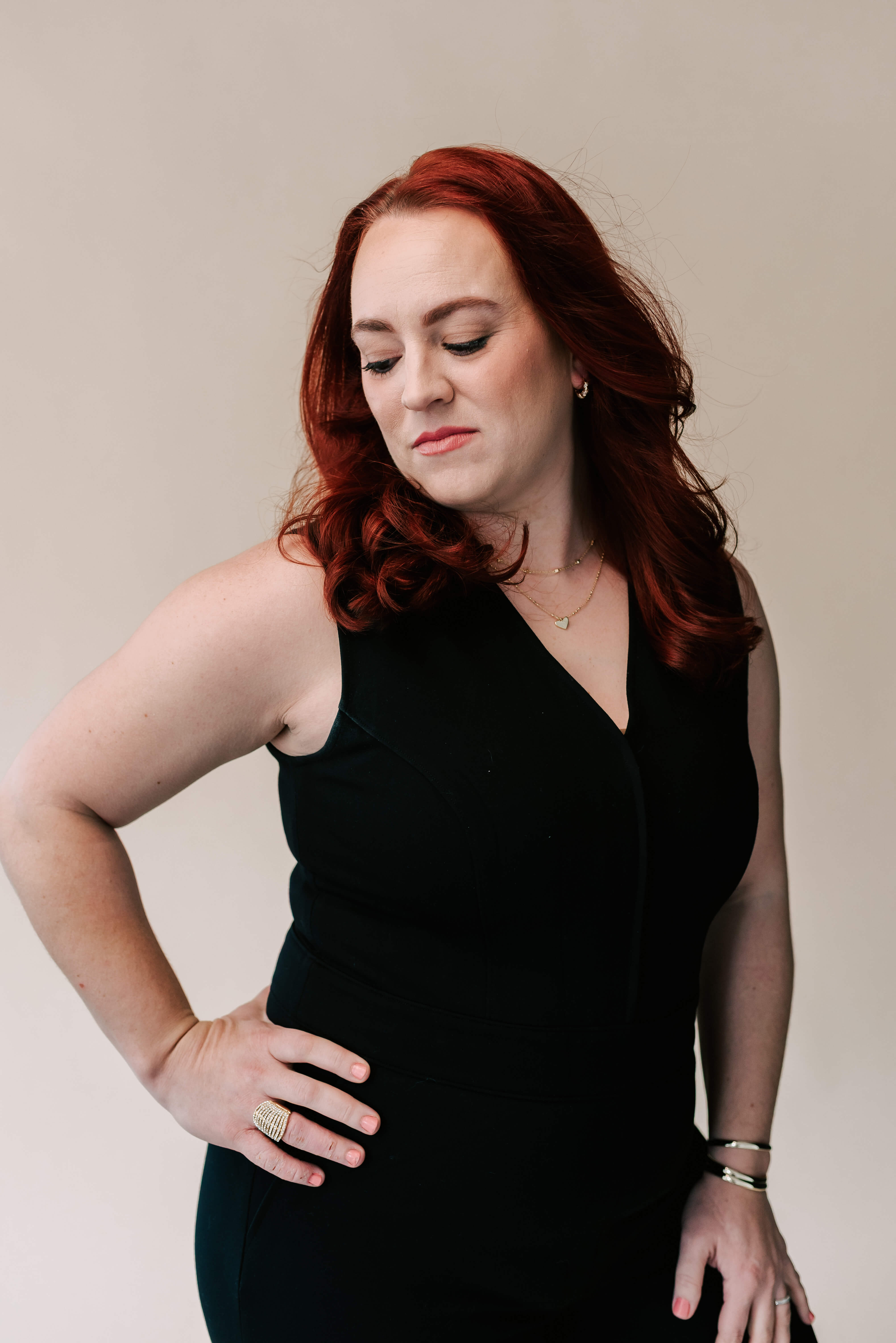 Berkeley County VW bookkeeper poses powerfully, hands on hips, in a sleek black tank dress against neutral background.