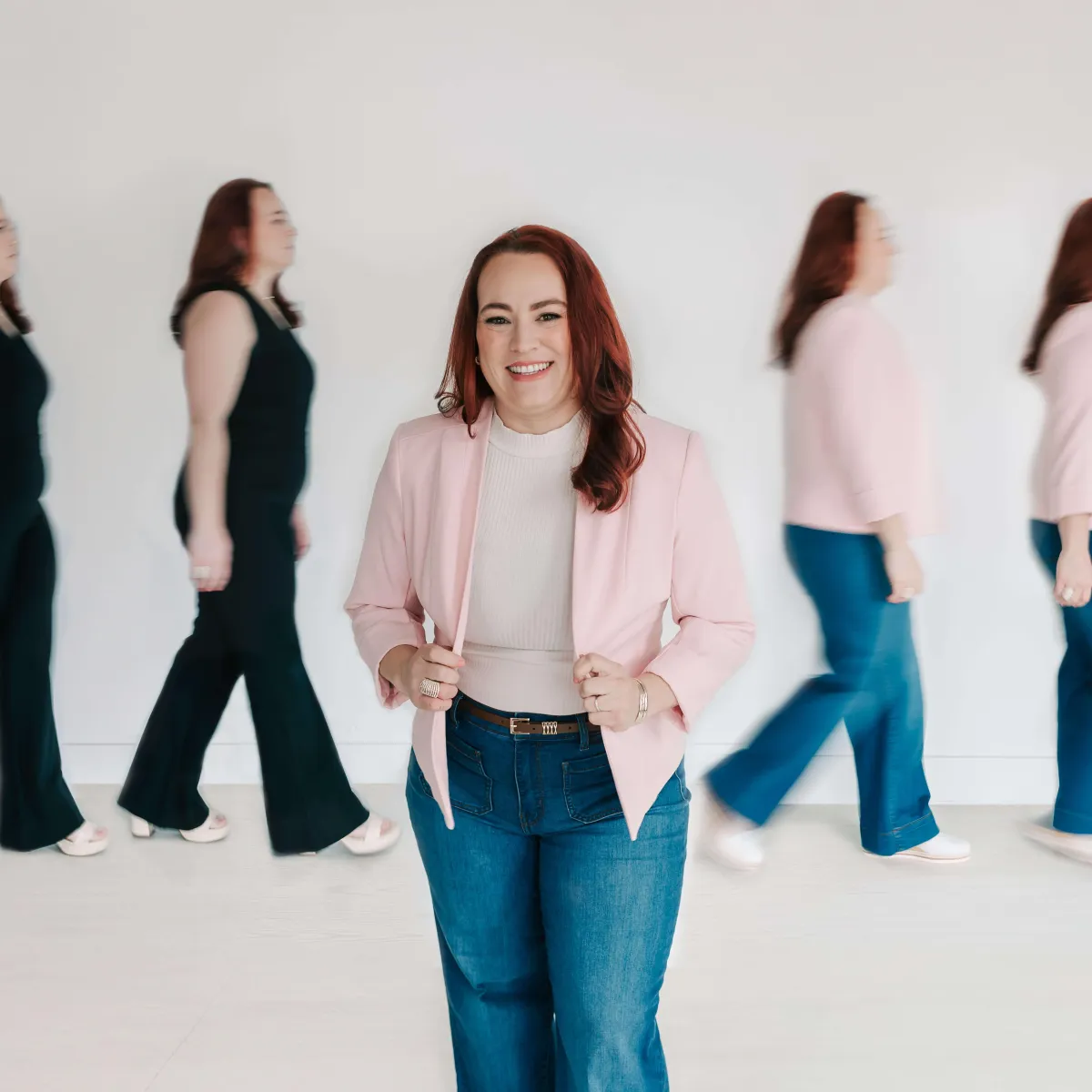 Jamie, a smiling CEO mom in pink blazer and jeans, poses sharply focused amid two blurred walking images of herself, for bookkeeping services.