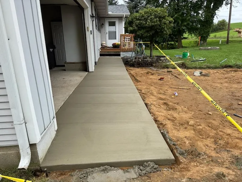 Freshly poured concrete walkway alongside a home in Grand Haven, MI.