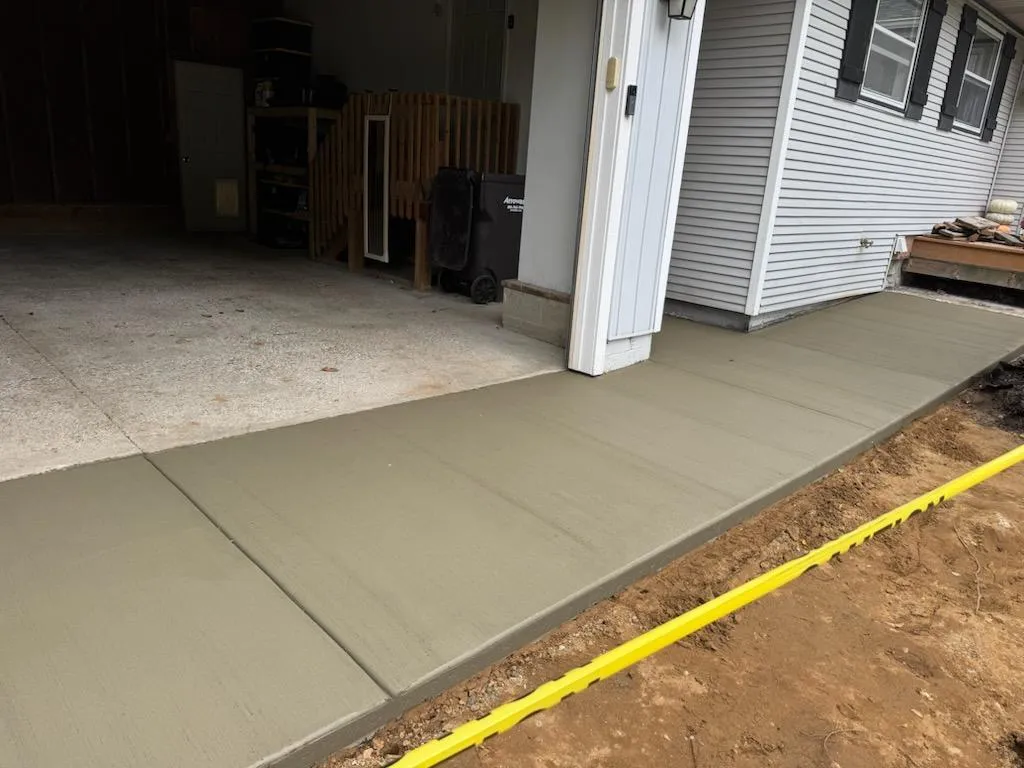 Freshly poured concrete apron and walkway outside a residential garage in Grandville, MI.