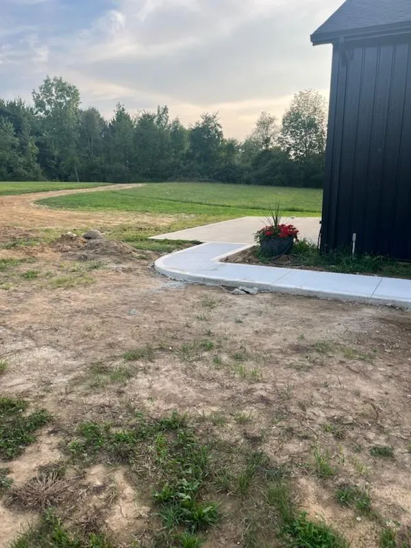 Finished concrete walkway and curved entry path beside a property serviced by Kelly’s Custom Concrete in West Michigan.