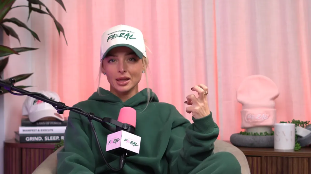 Editorial portrait of Savana Montana founder, a poised woman with natural curls, wearing a minimalist black dress, seated in a modern white chair against a soft green backdrop. The lighting is soft, and the composition is elegant, evoking confidence and creative energy.
