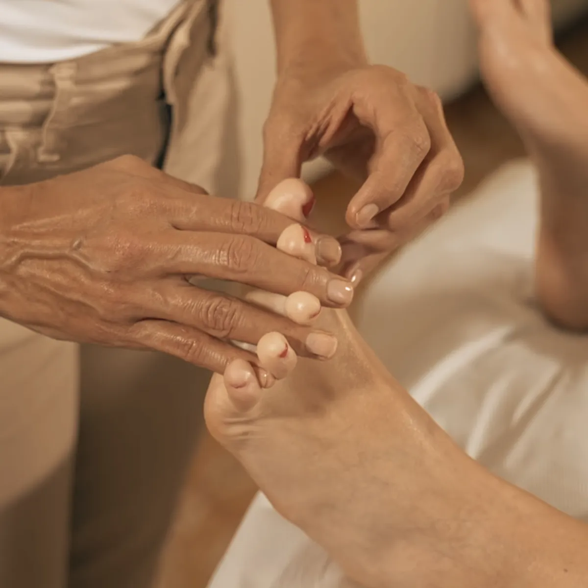 Somatic reflexology foot therapy session beside warm coastal stone archway