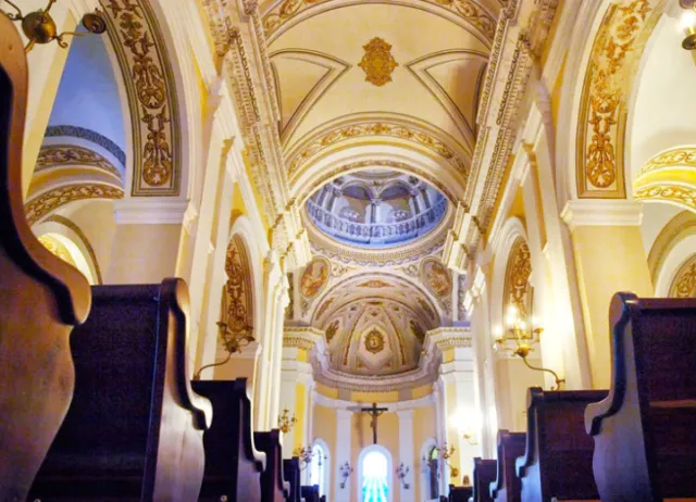 silhouette of person sitting on bench near body of water during daytime