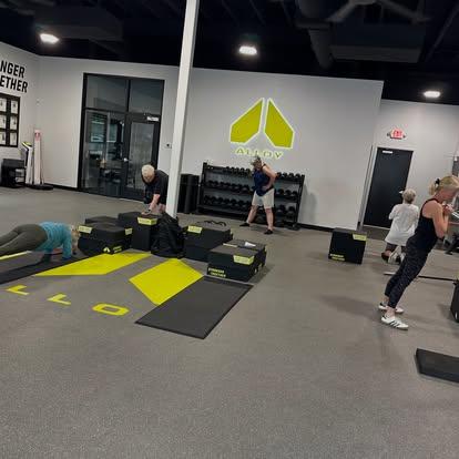 Small group personal training session at Alloy Personal Training Kaysville with adults performing functional strength exercises under the guidance of certified personal trainers.