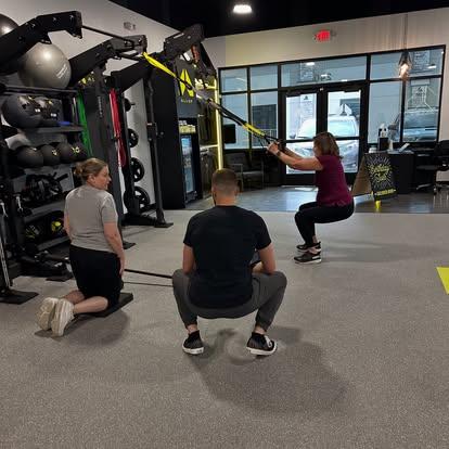 Small group personal training session at Alloy Personal Training Kaysville with adults performing functional strength exercises under the guidance of certified personal trainers.
