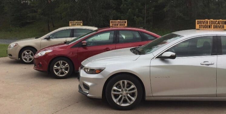 Driving instructor teaching teen student in car