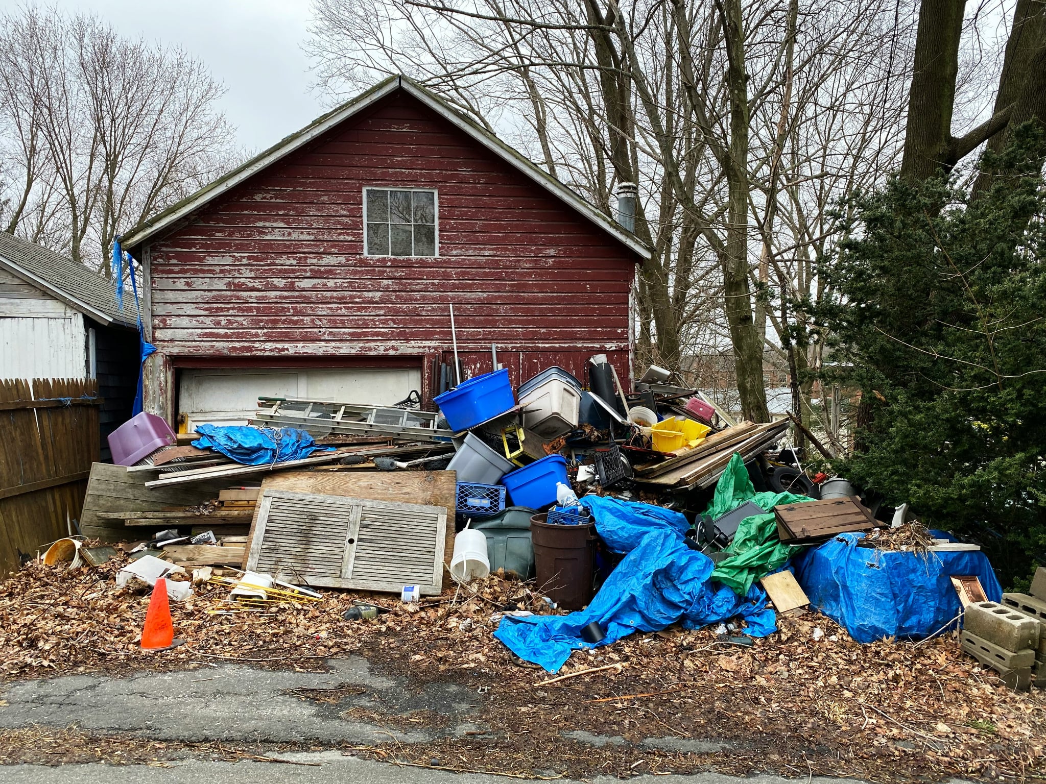 red house with a bunch of junk outside in front