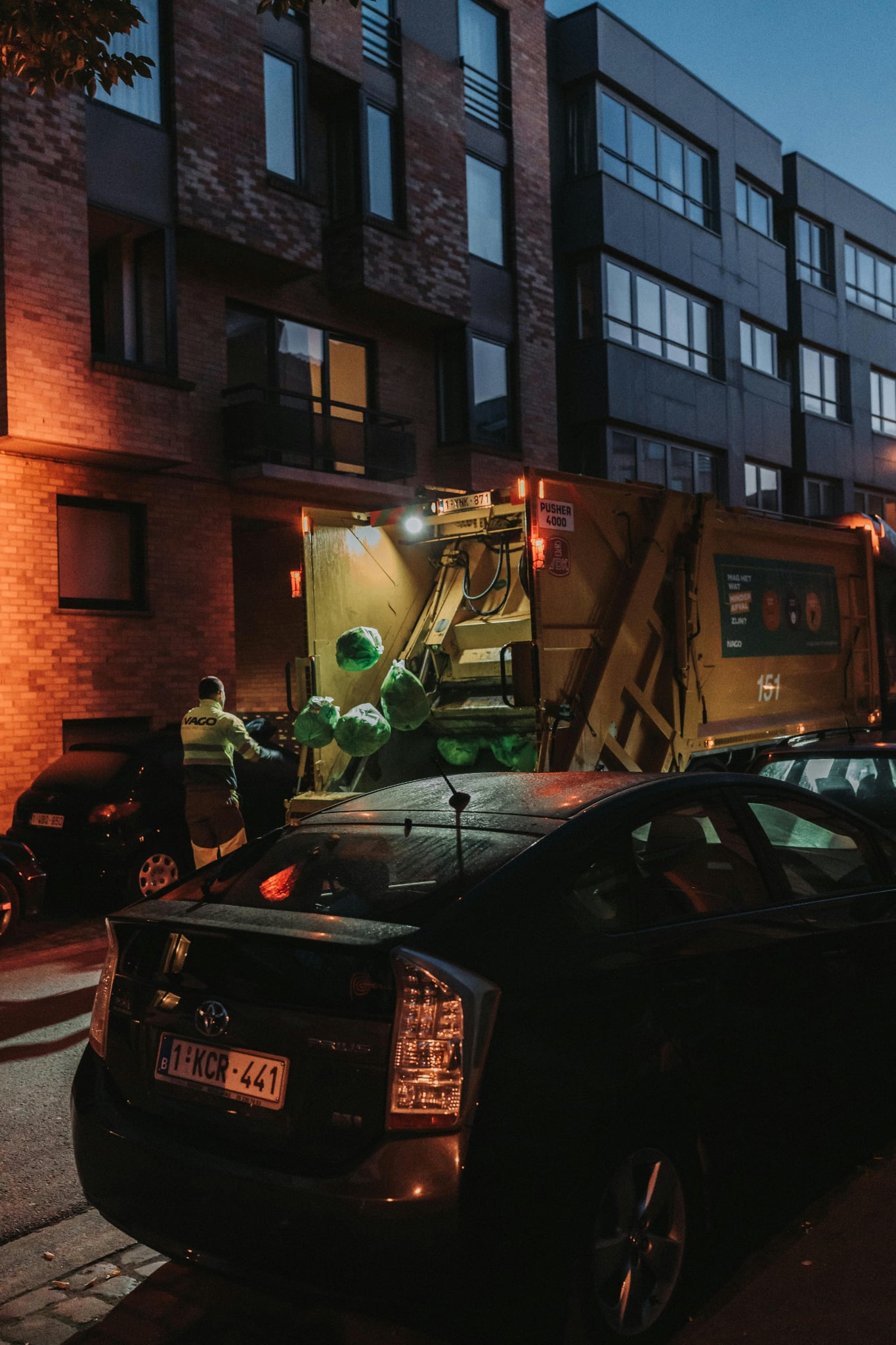 man loading plastic bag and dump in a garbage truck