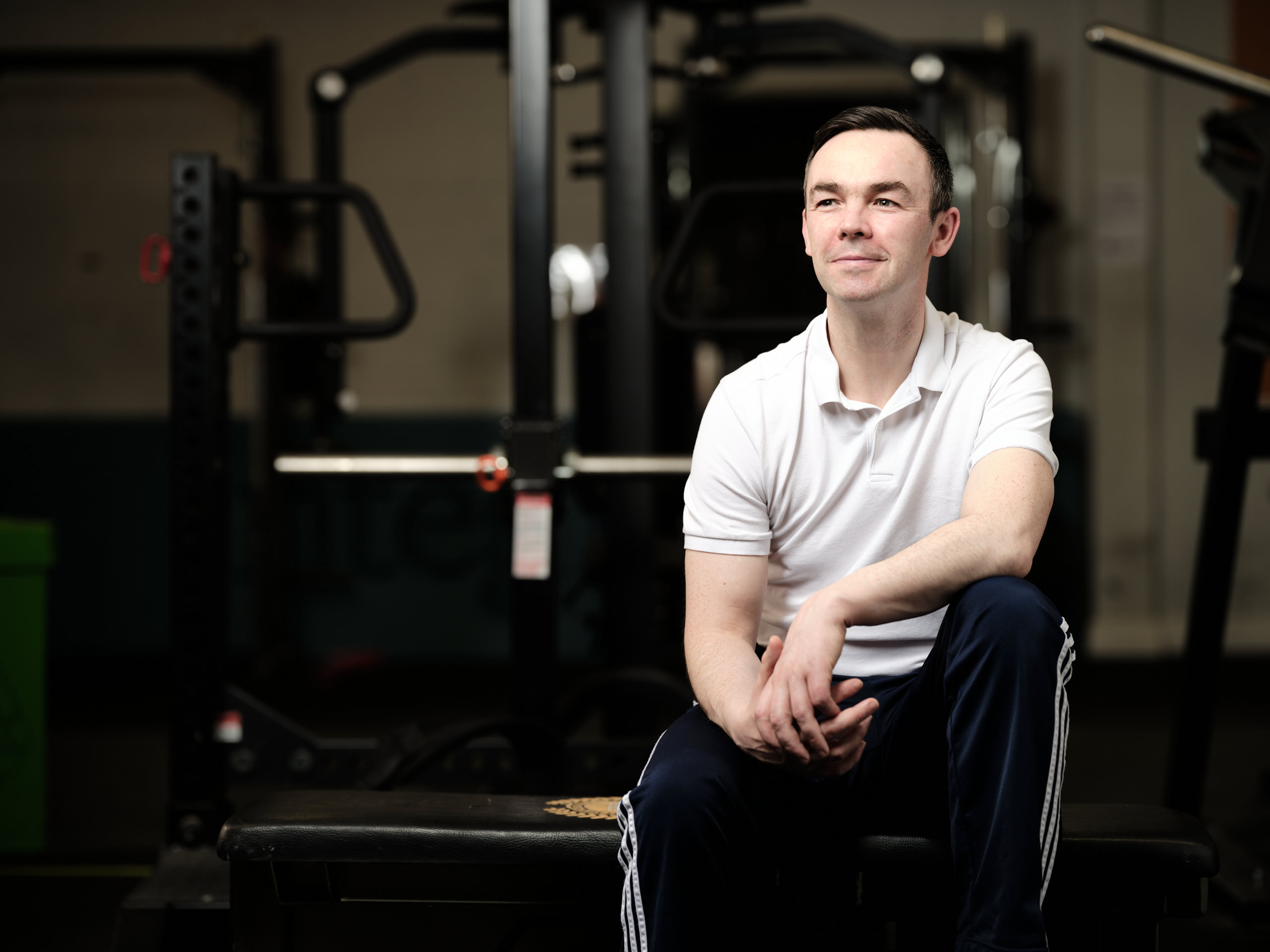 topless man in black shorts carrying black dumbbell