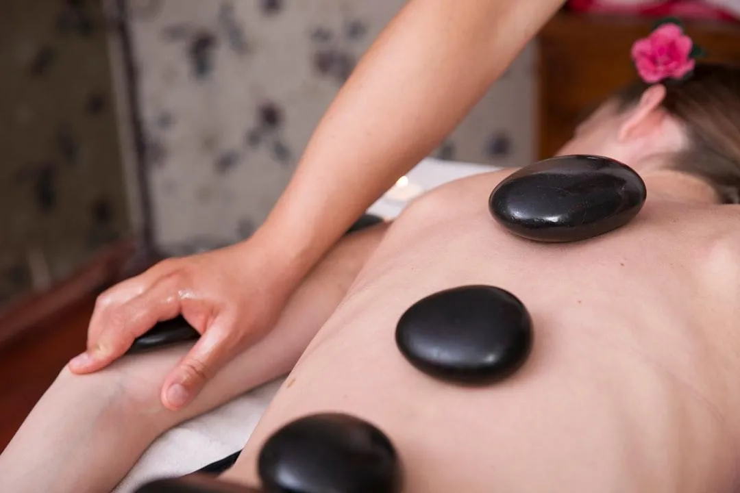 person getting hot stone massage therapy by rhonda brown ilinois