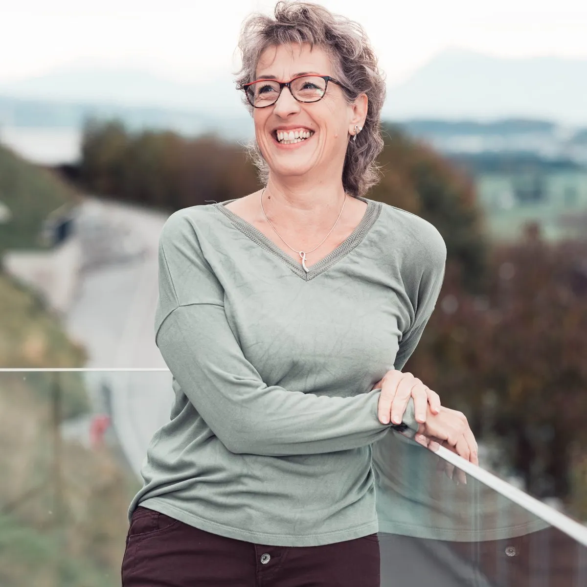 Claudia Hausheer von KlarSein lacht auf ihrem Balkon