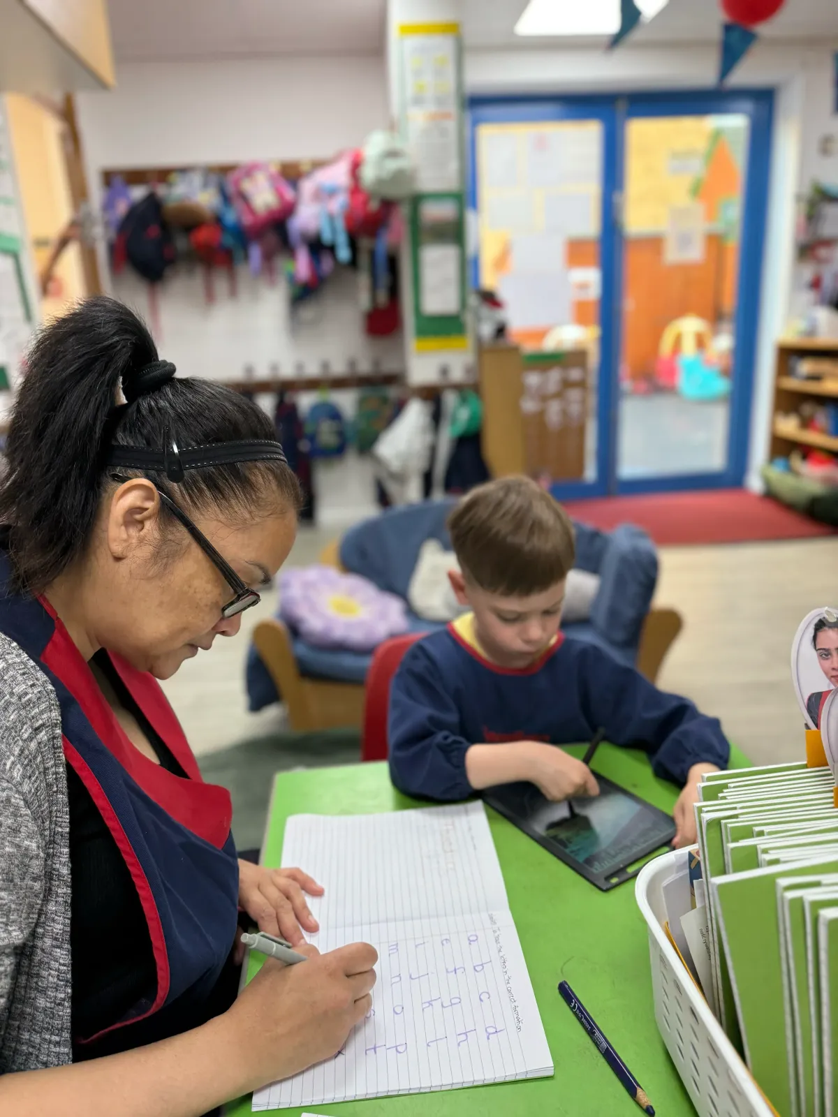 Early Years Educator checking Handwriting with key child