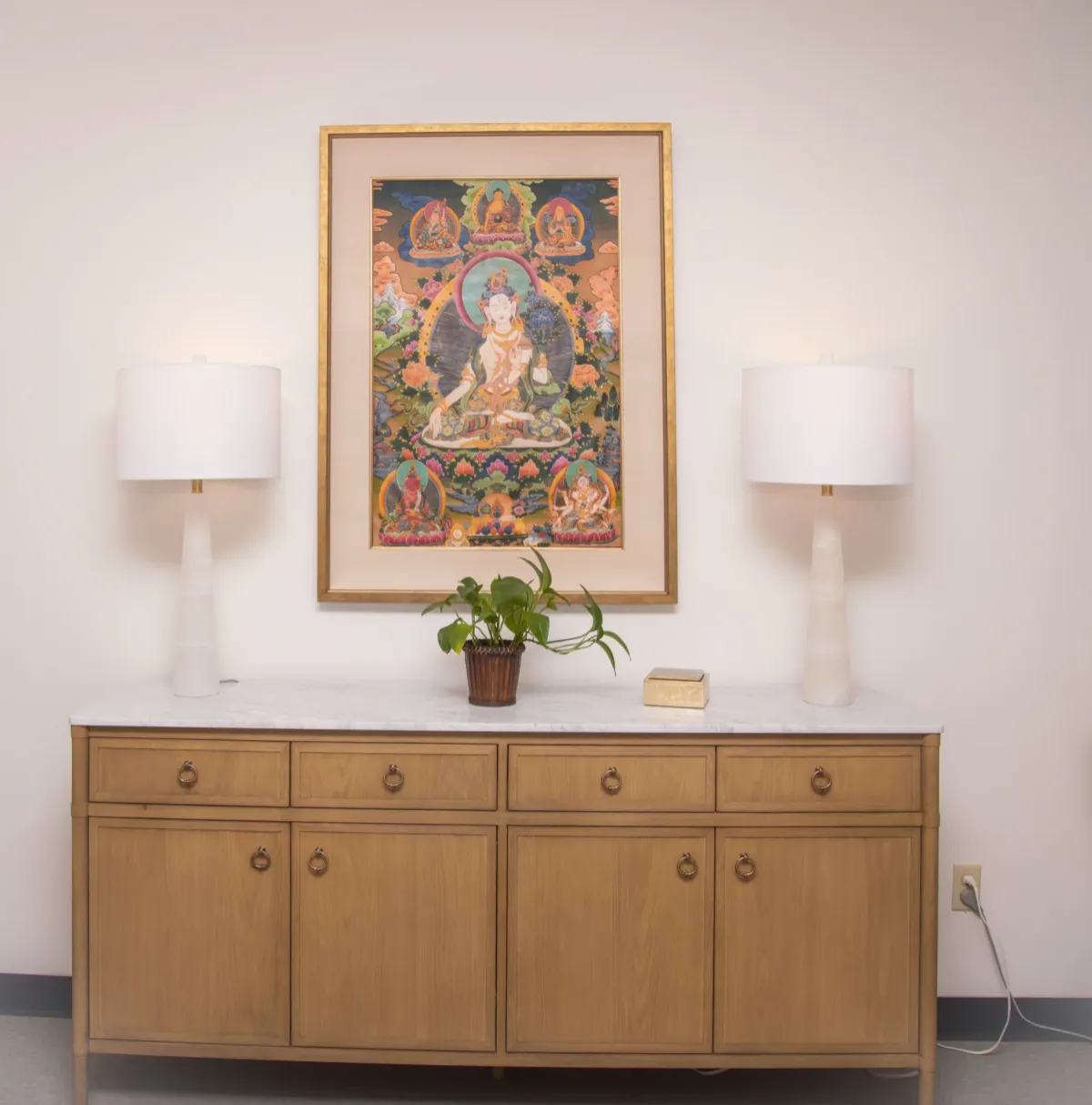 A console with lamps and framed artwork in the clinic