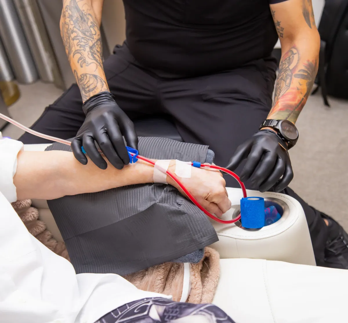 Gloved hands and contained tubing detail in a clinical setting