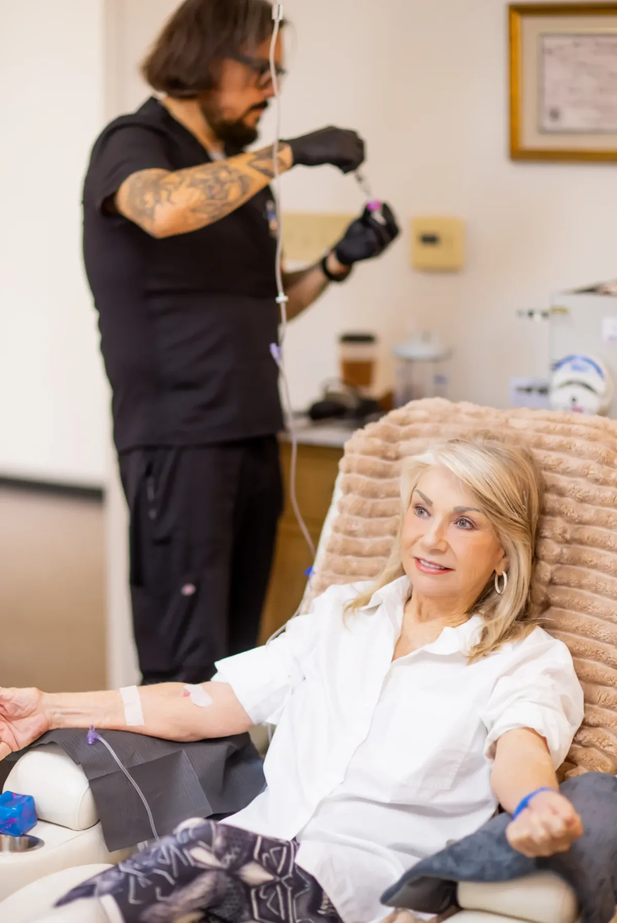 A standing staff member beside a treatment chair in a clinical setting