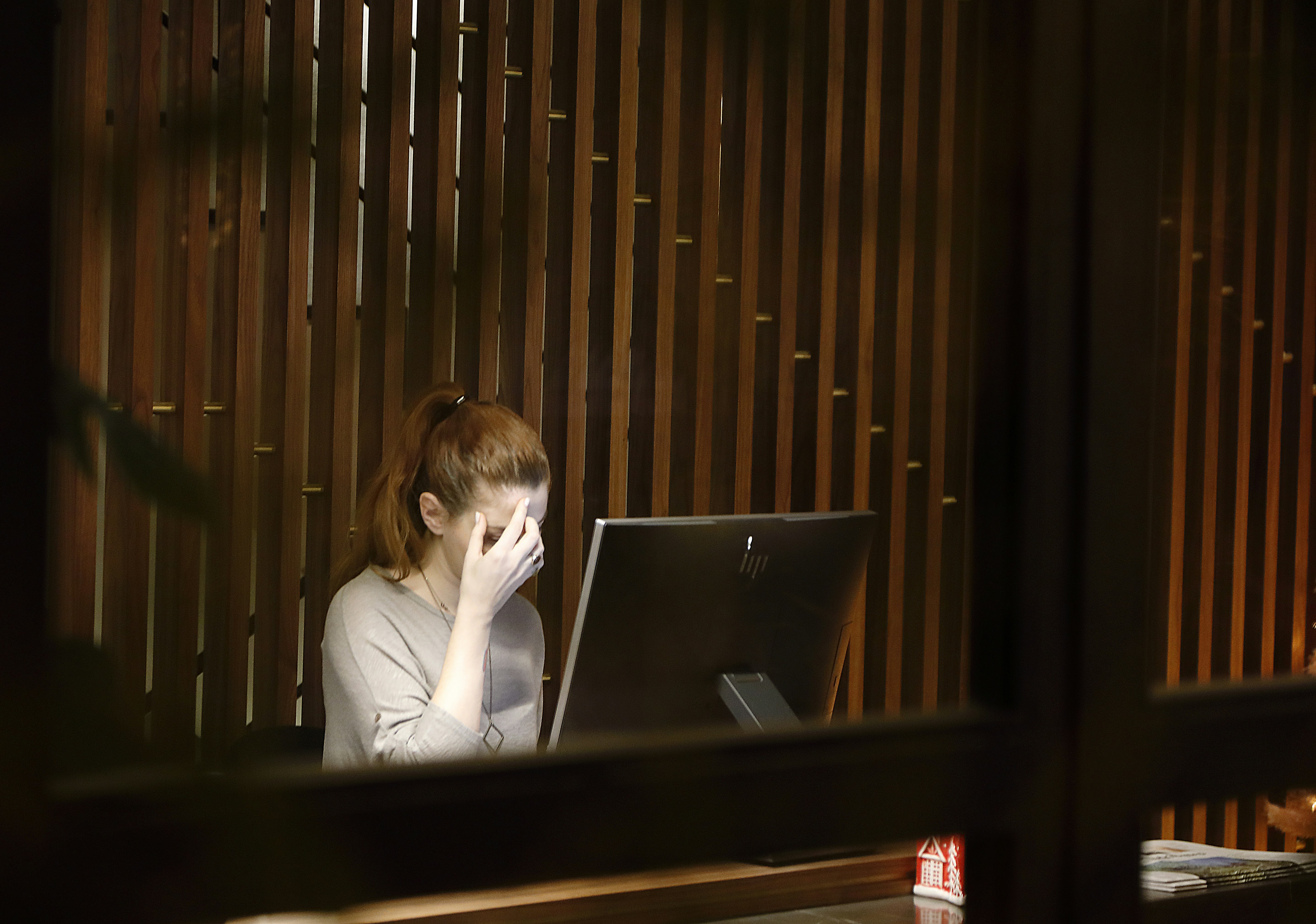 Woman working in dimply lit room on her computer.