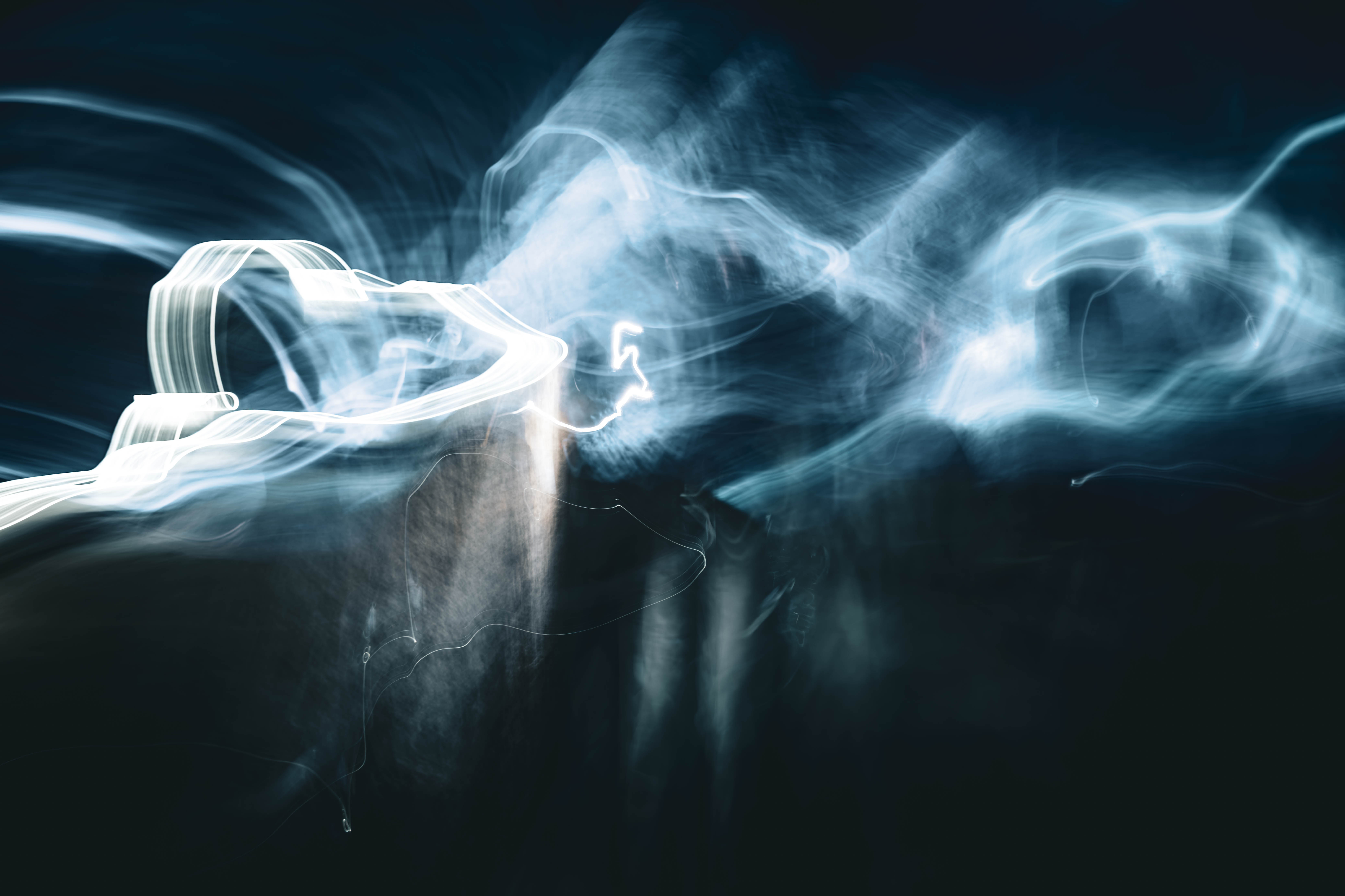 Abstract long exposure light photography inside the Zipaquirá Salt Cathedral, Colombia — luminous white light trails emerging from deep blue-black darkness. Fine art limited edition print by Angie Harker.