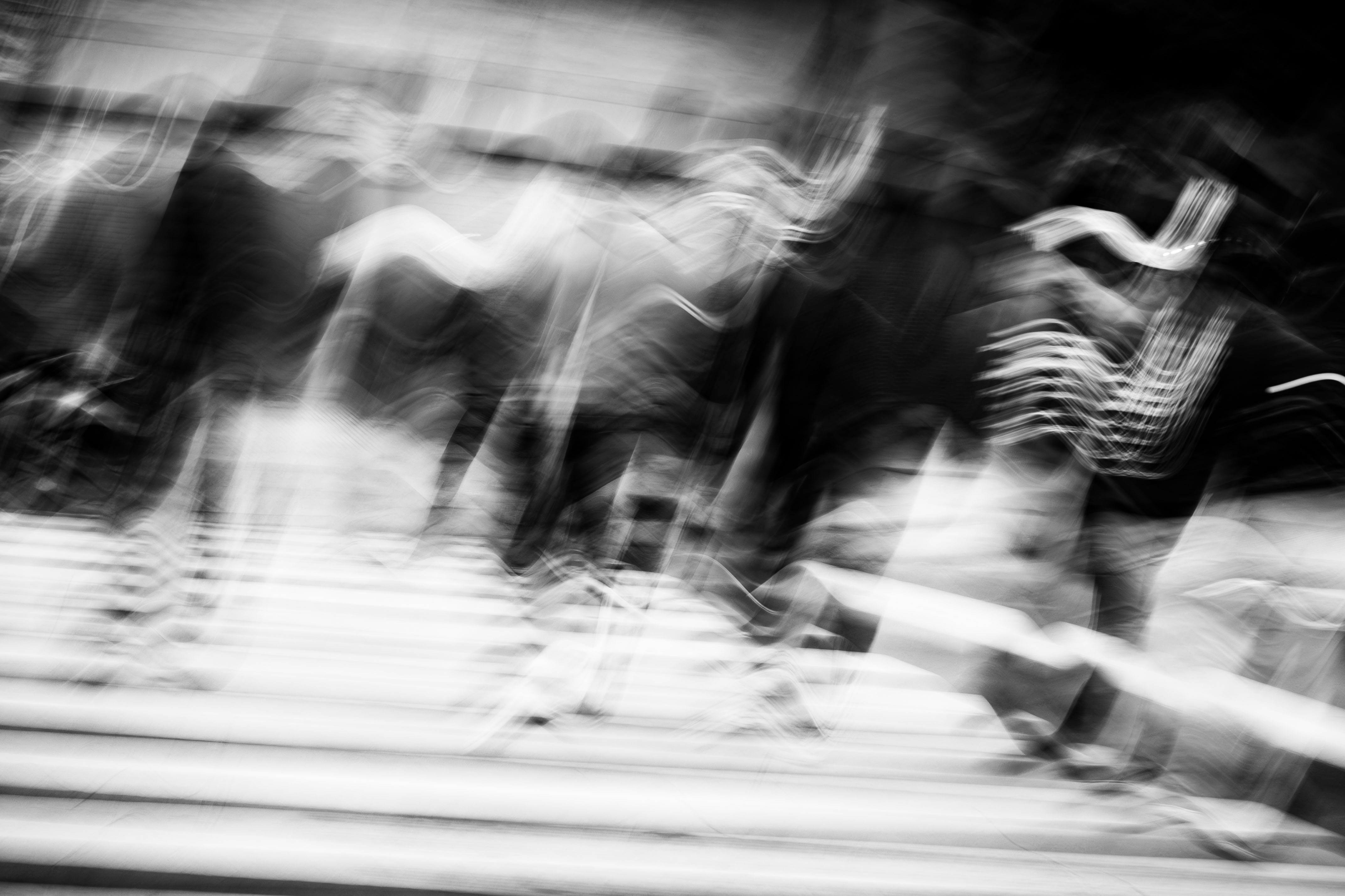 Ghosted figures and sinuous light trails moving through the Buenos Aires pedestrian zone, architecture bleeding through the upper register, baldosas striping the lower frame, tilted monochrome ICM fine art photograph by Angie Harker