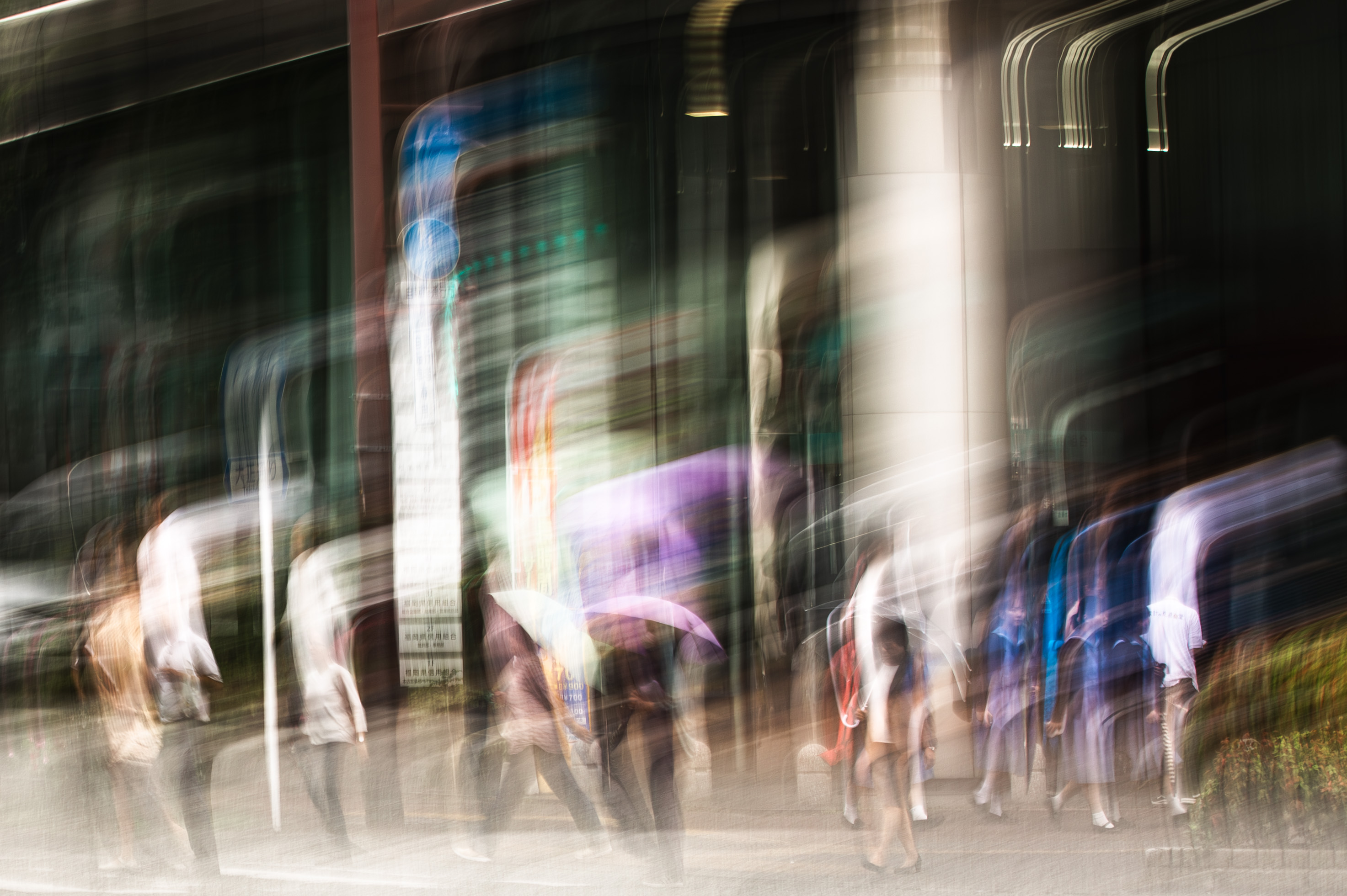 Long exposure ICM photograph of layered pedestrian silhouettes on a Fukuoka street in tropical rain, figures caught at multiple points in their own movement, by fine art photographer Angie Harker