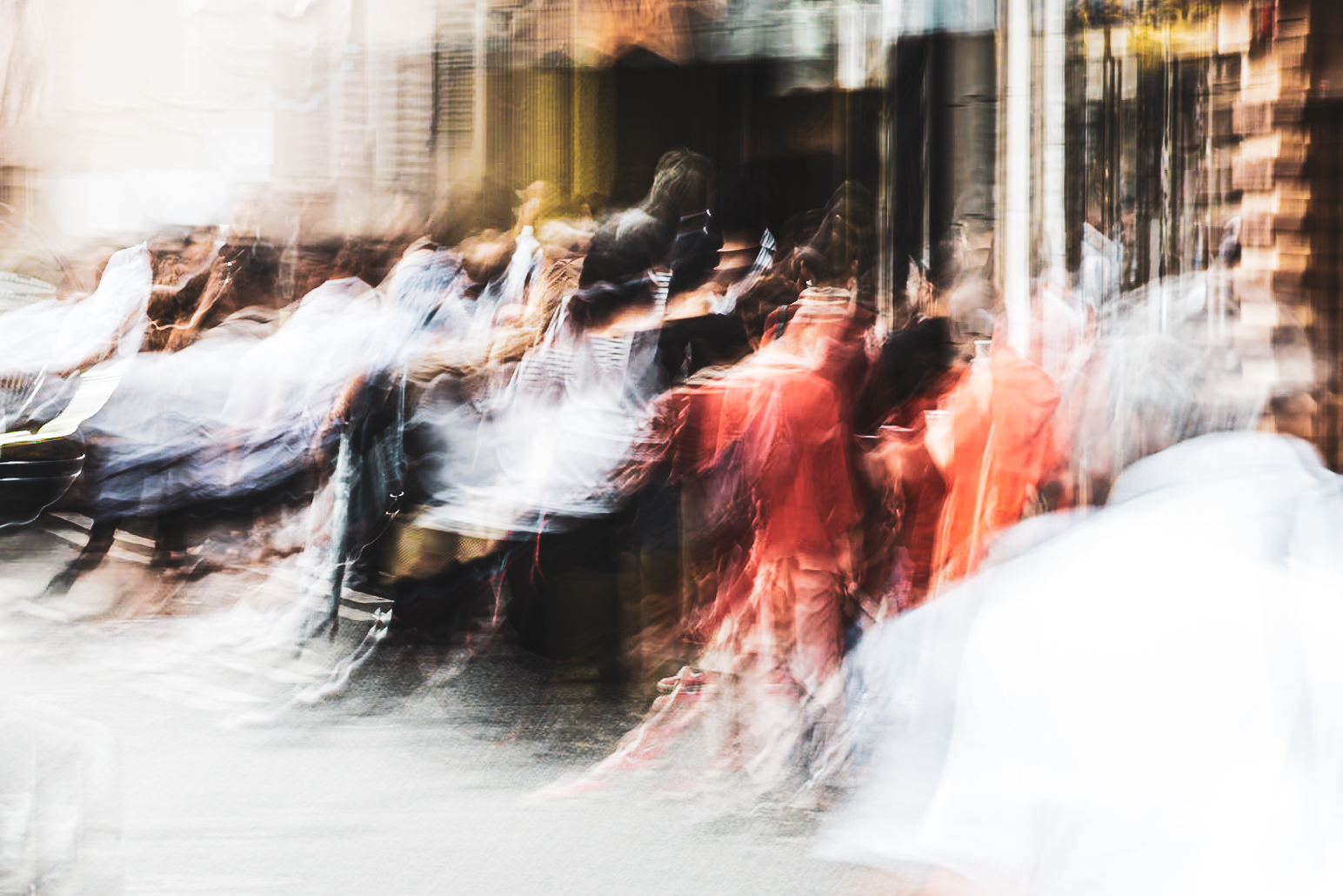 Long exposure ICM photograph of figures queuing in tropical rain on a Fukuoka street, one figure still moving in the foreground, the red at centre holding while everything else lifts, by fine art photographer Angie Harker