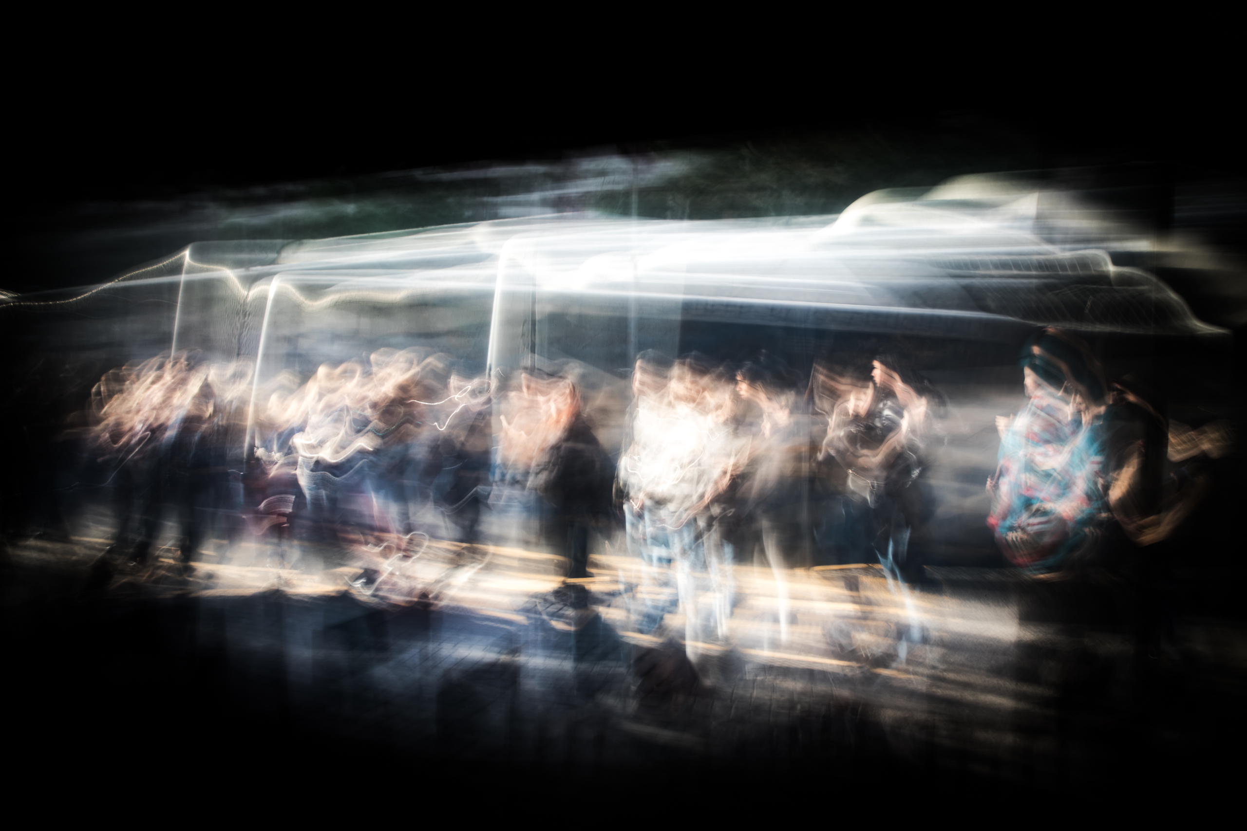 Long exposure ICM photograph of commuters waiting at a bus stop on Diagonal Norte, Buenos Aires, figures held in tension against the motion of the city, by fine art photographer Angie Harker