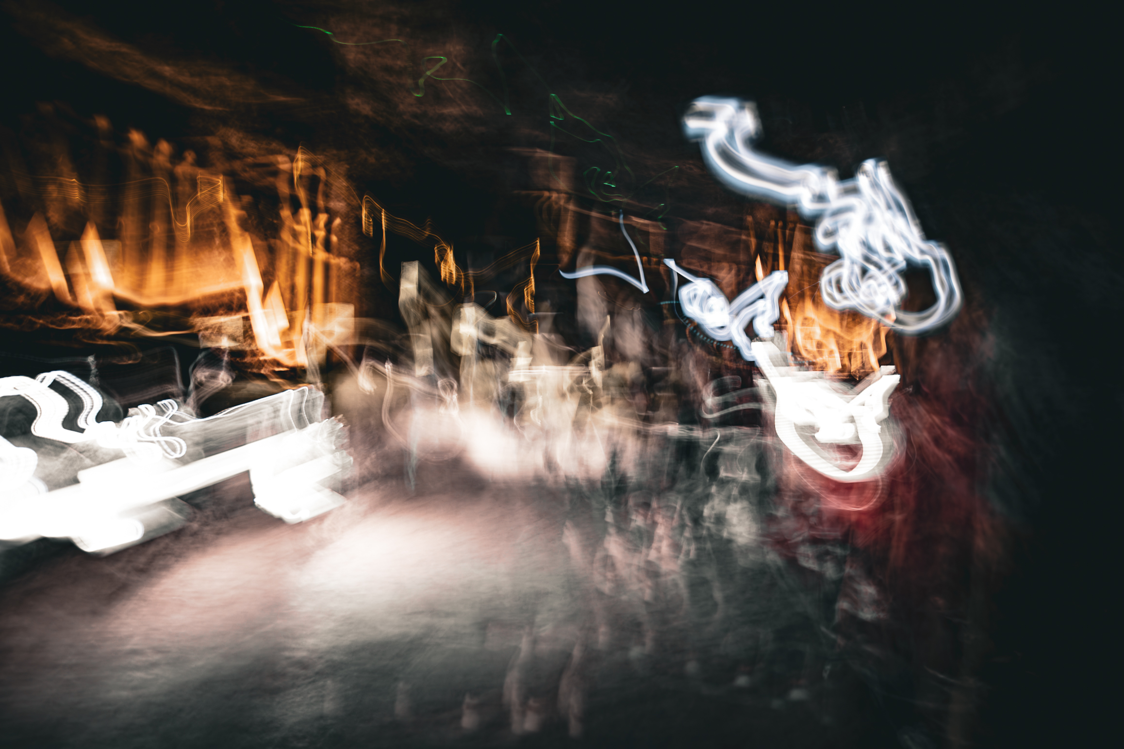 Long exposure ICM abstract photograph of figures processing through the Salt Cathedral of Zipaquirá, Colombia, colors bleeding and blending in sacred dark, by fine art photographer Angie Harker