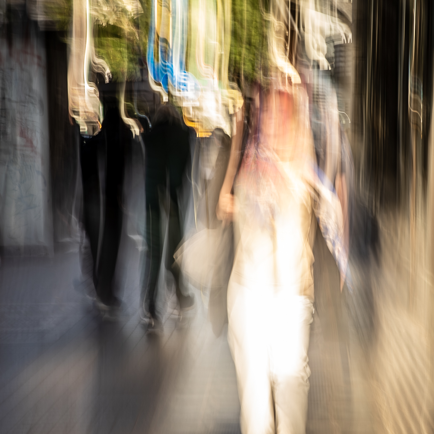 Long exposure ICM photograph of figures stretching and dissolving along a Buenos Aires street at dusk, one presence glowing mid-transition, by fine art photographer Angie Harker