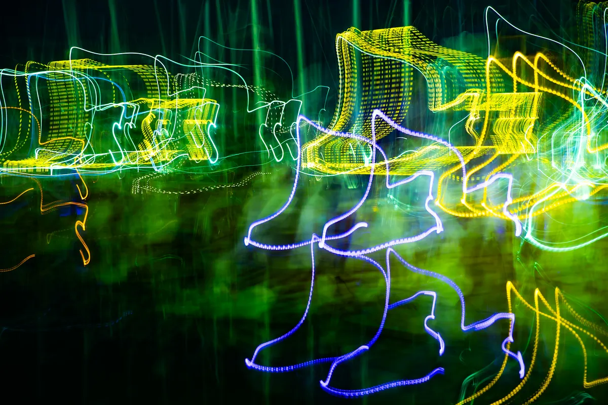 Long exposure ICM photograph of light trails on water at Dana Point marina at night, the unseen current of the tide rendered in electric light, by fine art photographer Angie Harker