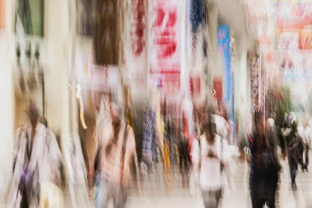 Long exposure ICM photograph of schoolgirls in uniform crossing a Kumamoto street in tropical rain, composed and refined amid the dissolving city, by fine art photographer Angie Harker