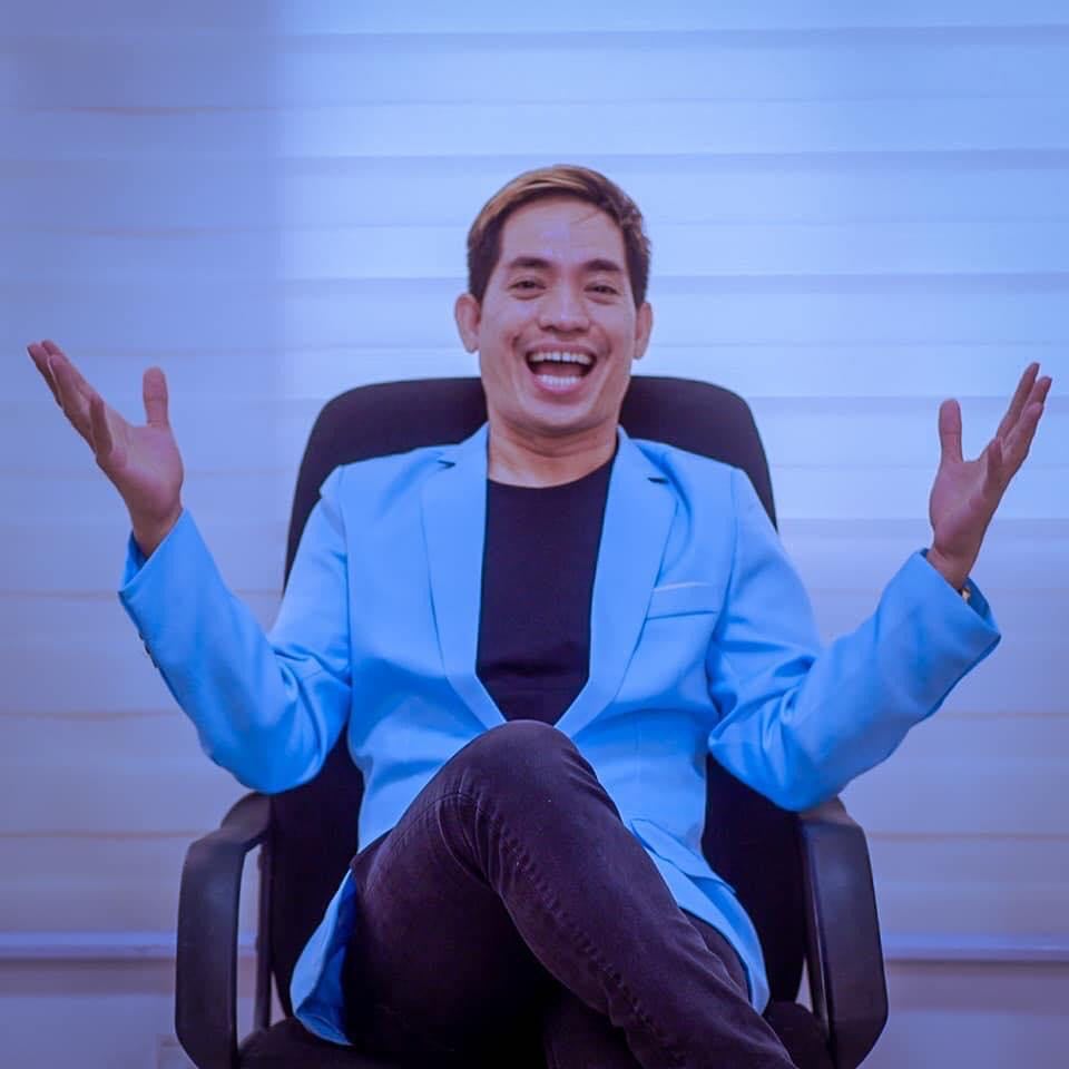 A 1:1 portrait of Isabella Rossi, a white Italian woman in her 50s, with short silver hair, wearing a tailored black dress, seated at a conference table with blueprints, radiating expertise and warmth.