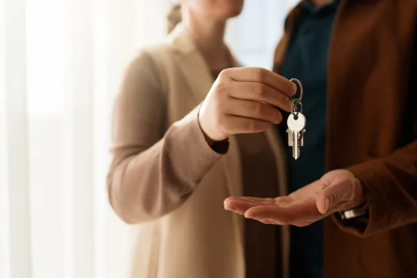 homeowner reviewing lease documents and keys preparing to rent out property