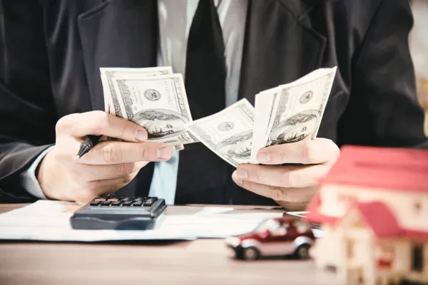 Investor reviewing financial documents at kitchen counter with laptop and coffee, representing strategic real estate investment planning in Ashburn Virginia