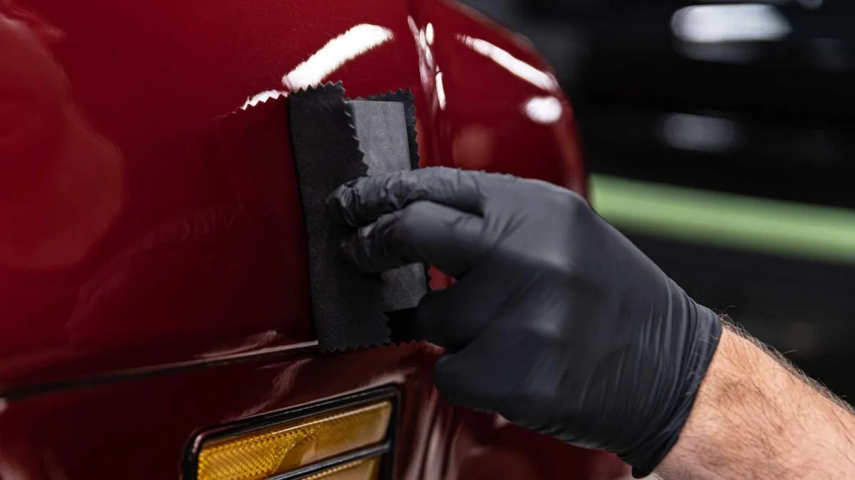 Glossy red car hood with ceramic coating applied in Central Florida driveway