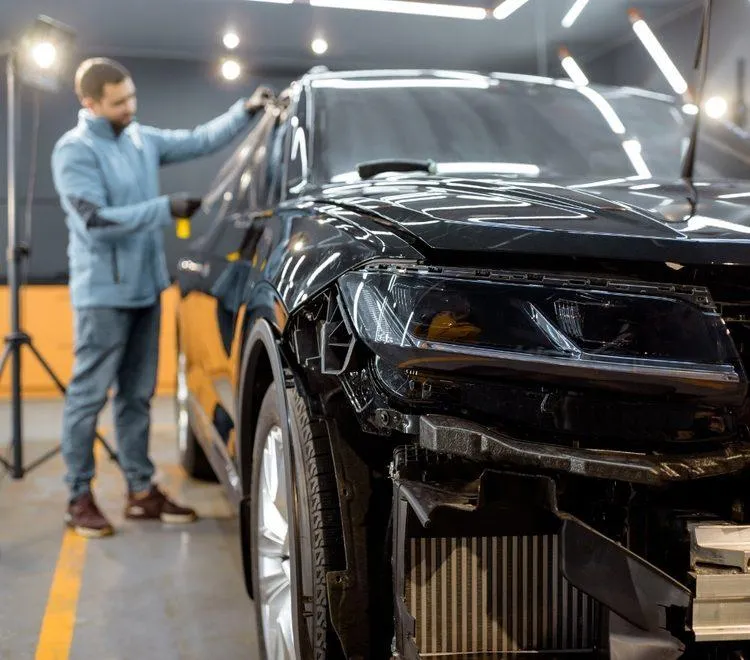 Car detailing technician with phone ready for appointment booking