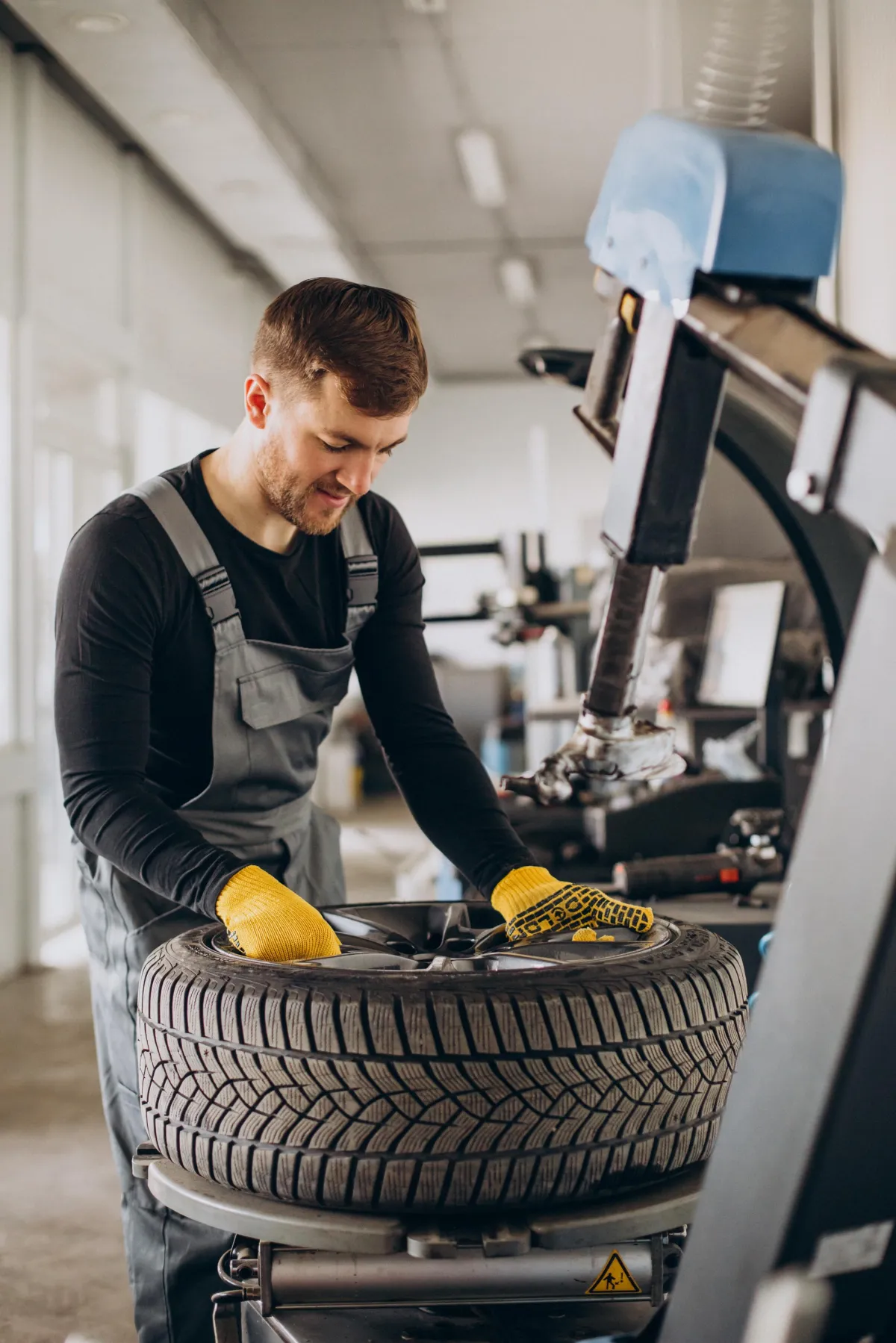Mechanic performing wheel alignment at tire shop in St. Louis – Overland Tire & Auto.