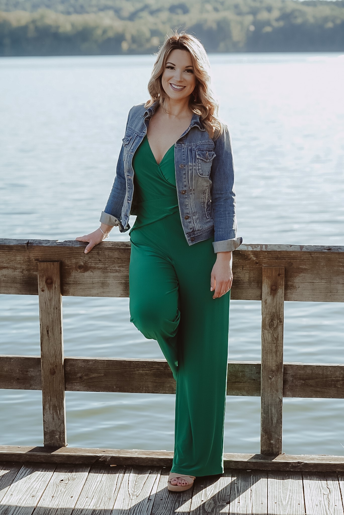 A confident woman in her 30s, seated at a desk with a laptop and notepad, thoughtfully filling out an application form. The workspace is organized and bright, with subtle insurance-themed decor, reflecting professionalism and focus.