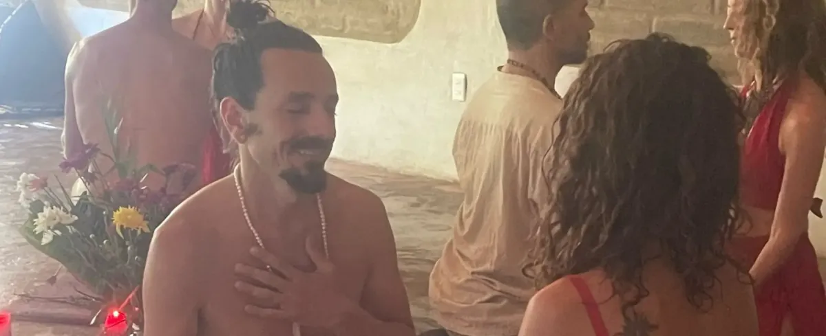 Participants in a tantra retreat ceremony, hand on heart, embodying sacred sexuality practice