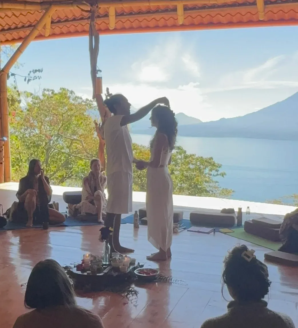Couple performing a sacred union ceremony overlooking the lake, with retreat guests witnessing