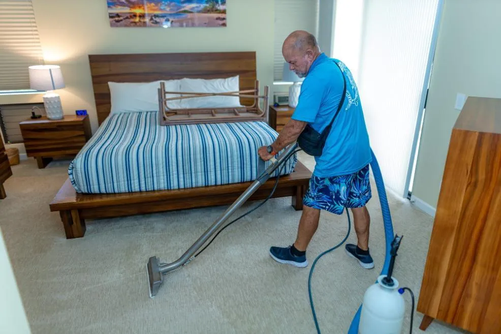Technician using professional equipment for carpet cleaning on Maui