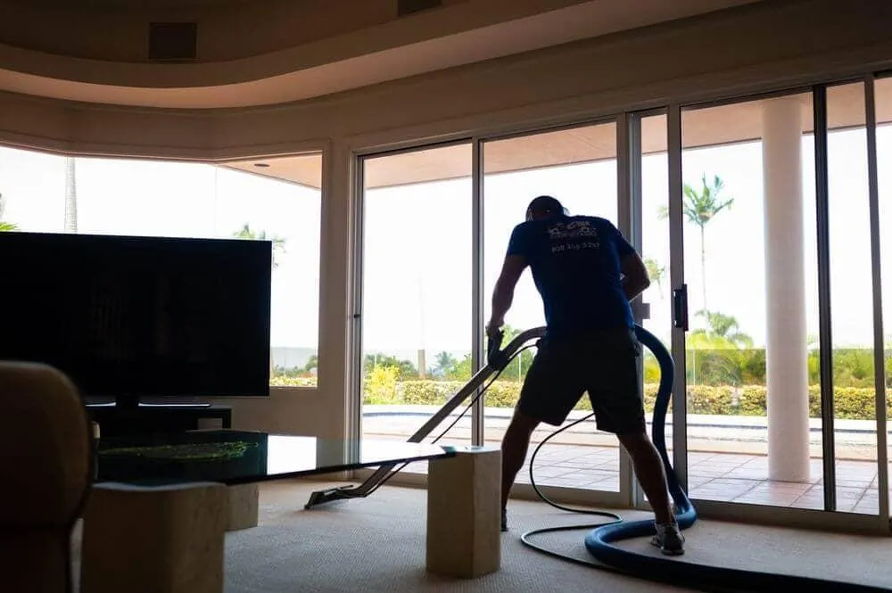 Technician steam cleaning living room carpet in Maui Meadows