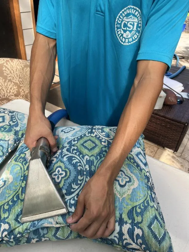 Upholstery technician steam cleaning a couch cushion