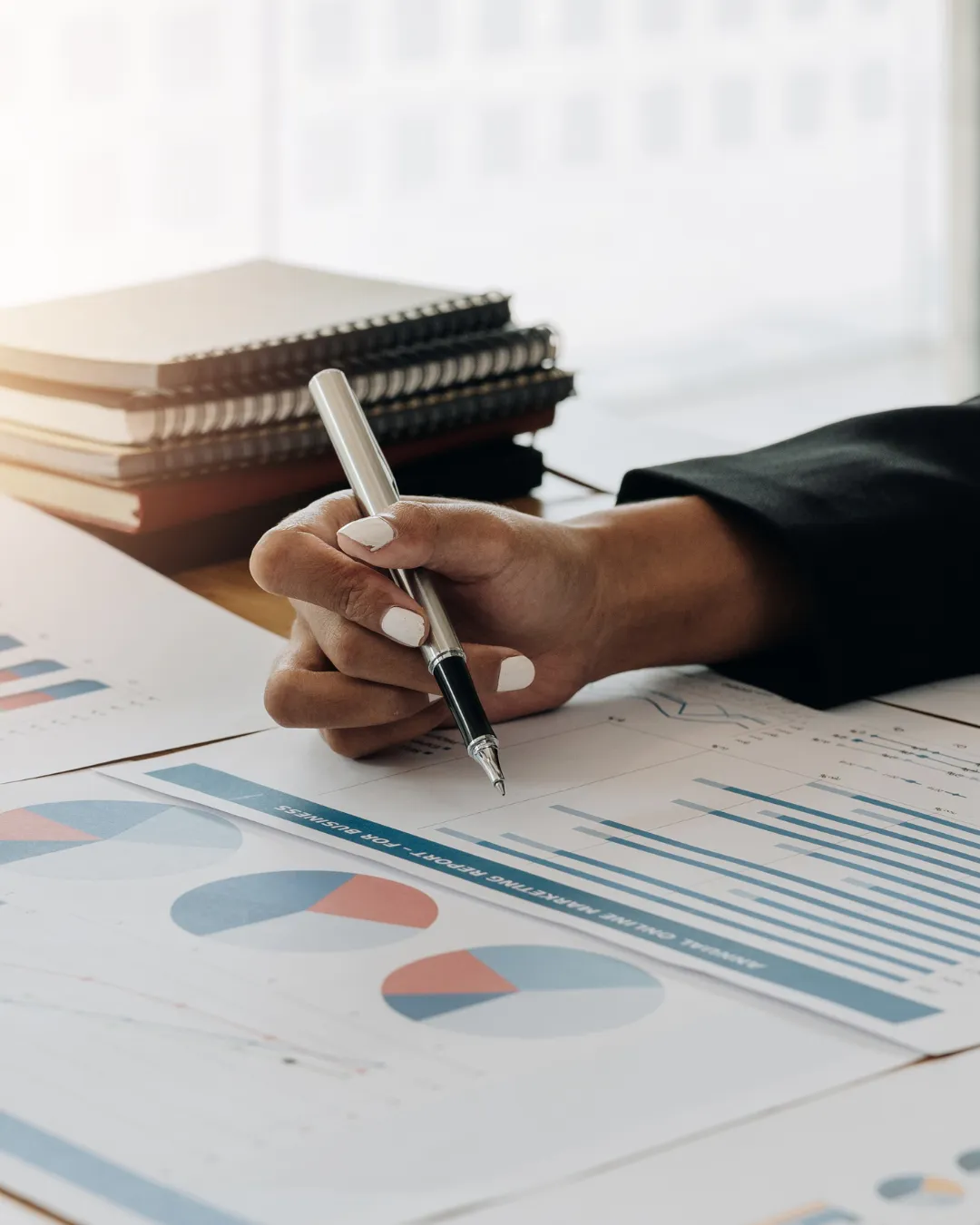 Equipa multicultural de gestores imobiliários portugueses reunida numa sala moderna, analisando documentos e sorrindo, ambiente profissional, luz natural, estilo documental, composição quadrada.